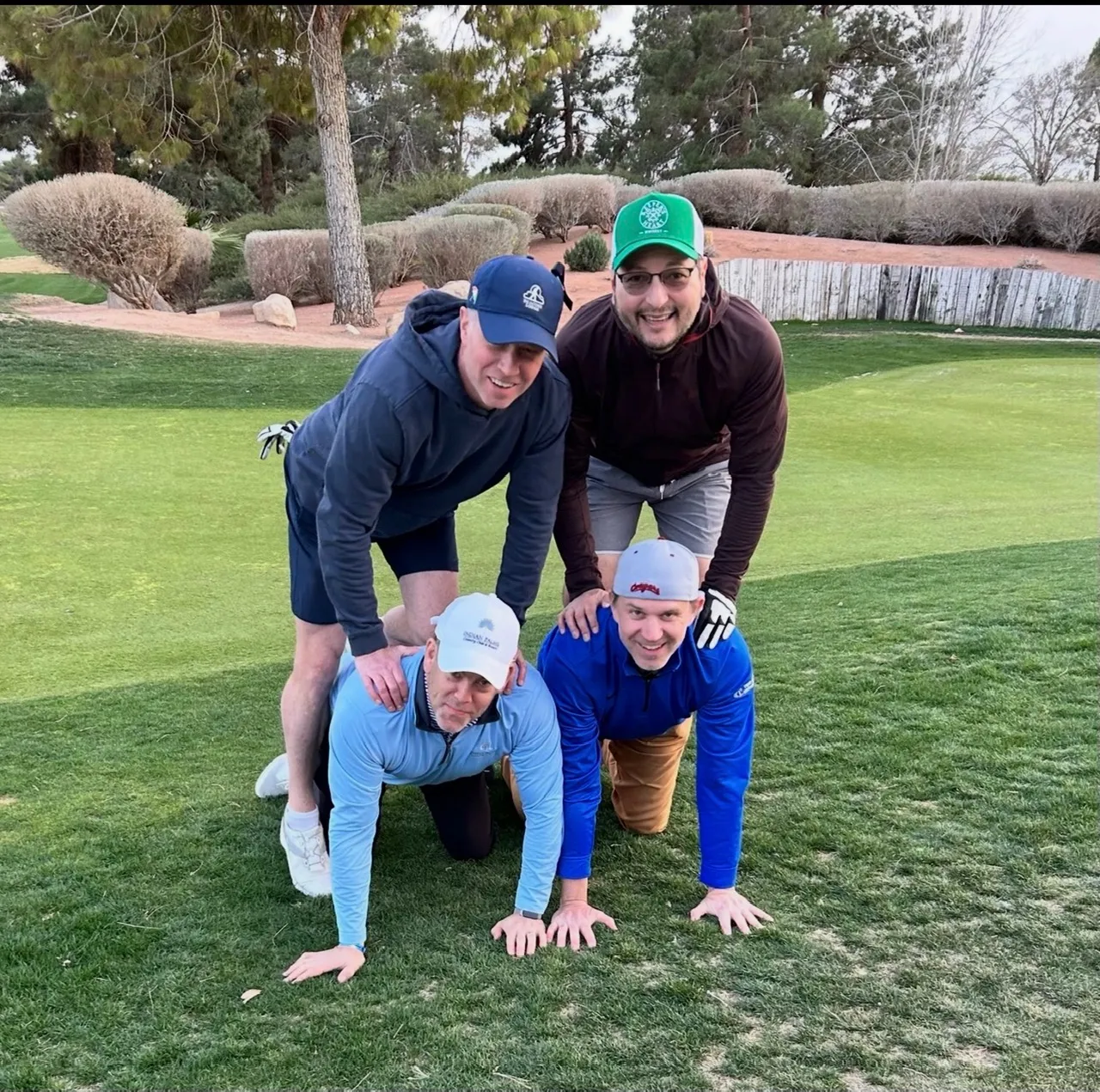 A foursome stacked in a pyramid on the fairway